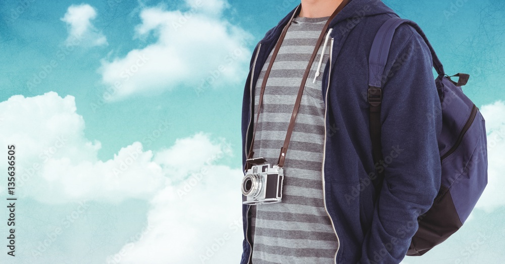 Mid section of man with backpack and digital camera