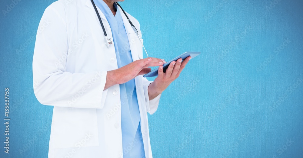 Mid section of doctor using digital tablet