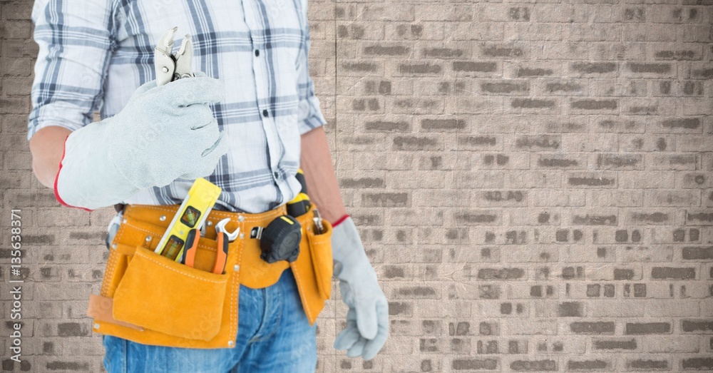 Mid section of handyman holding pliers