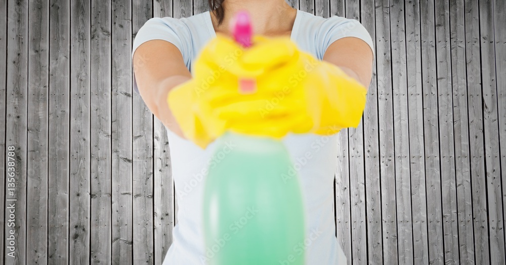 Mid section of woman holding spray bottle