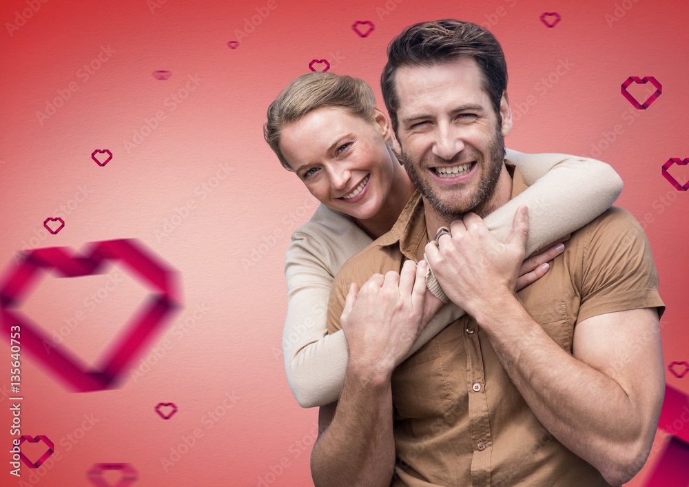 Portrait of couple against digitally generated hearts background