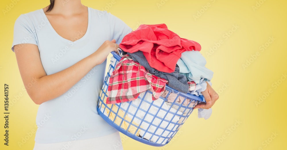 Mid section of woman holding bucket full of clothes