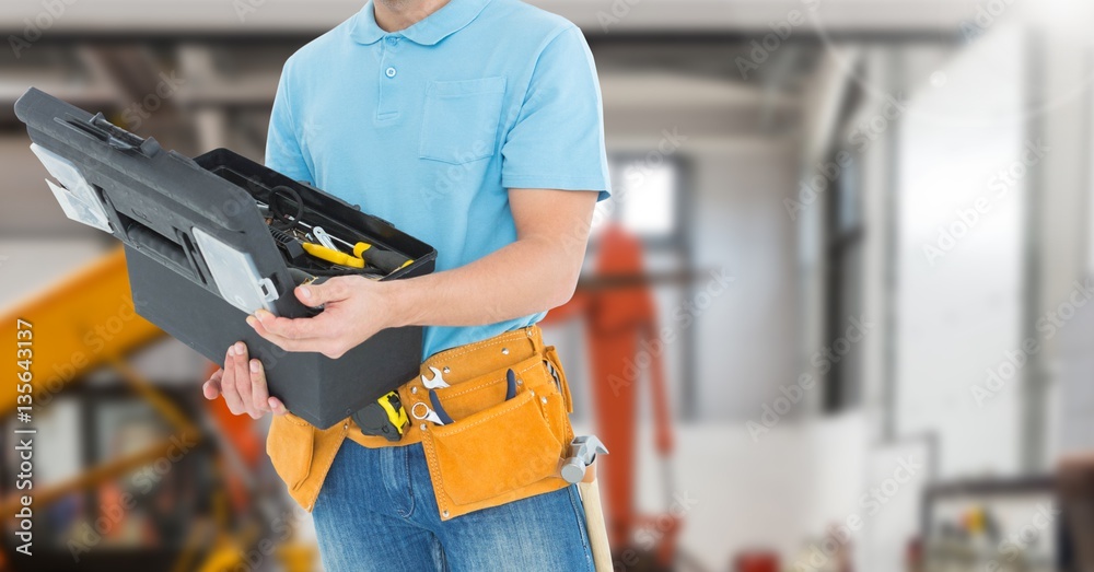 Mid section of handyman holding toolbox