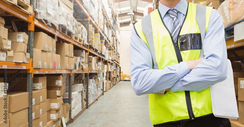 Mid section of worker standing with arms crossed