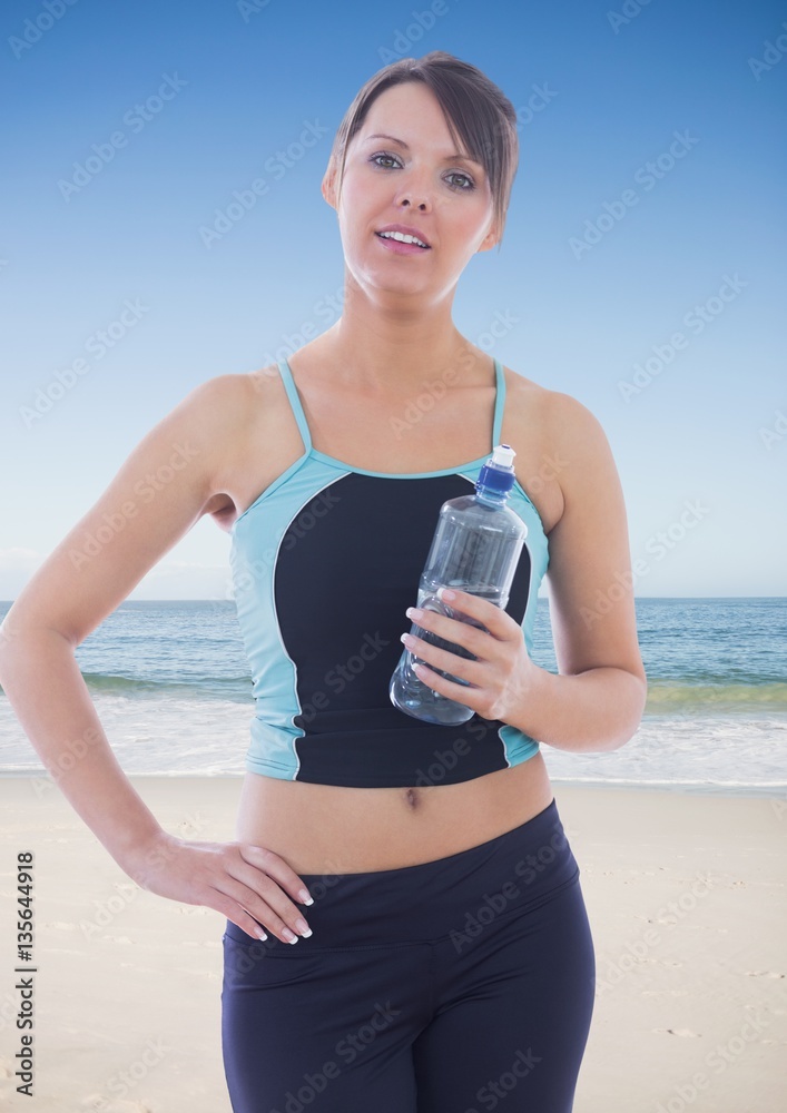 Portrait of fit woman standing with water bottle