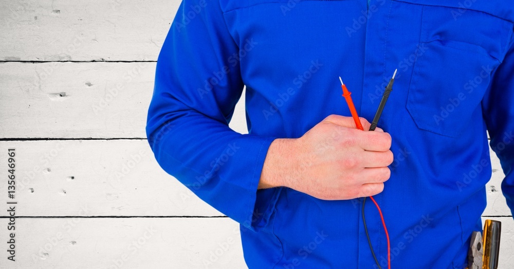 Handy man standing with cables against wooden background