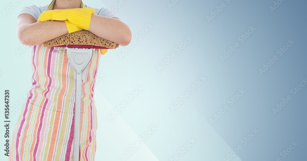 Female cleaner standing with mop against blue background