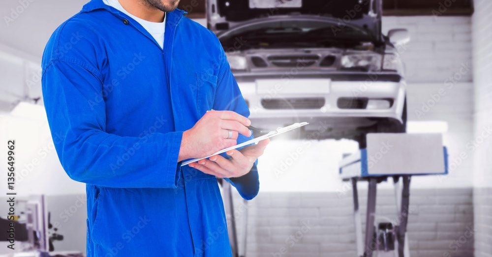 Mechanic writing on clipboard at garage