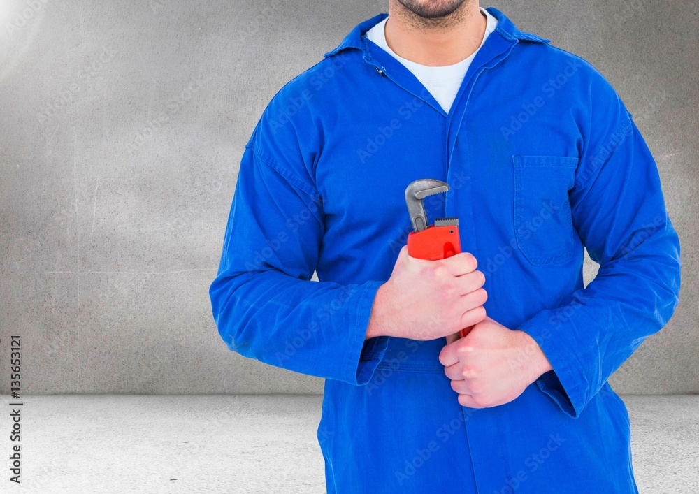 Mid section of handyman holding pipe wrench