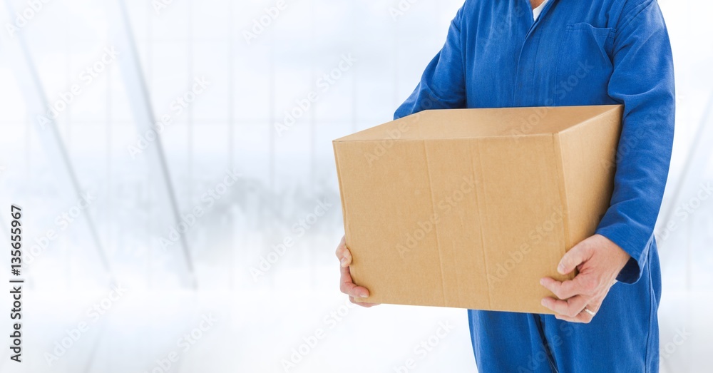 Delivery man holding a box against white background