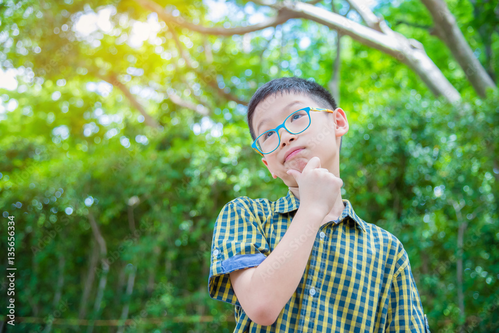 Young Asian boy thinking in garden