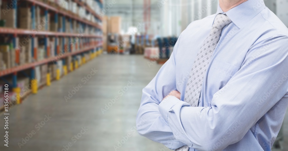 Manager standing with arms crossed in warehouse