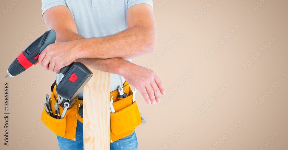 Mid section of handyman with tool belt and drill machine