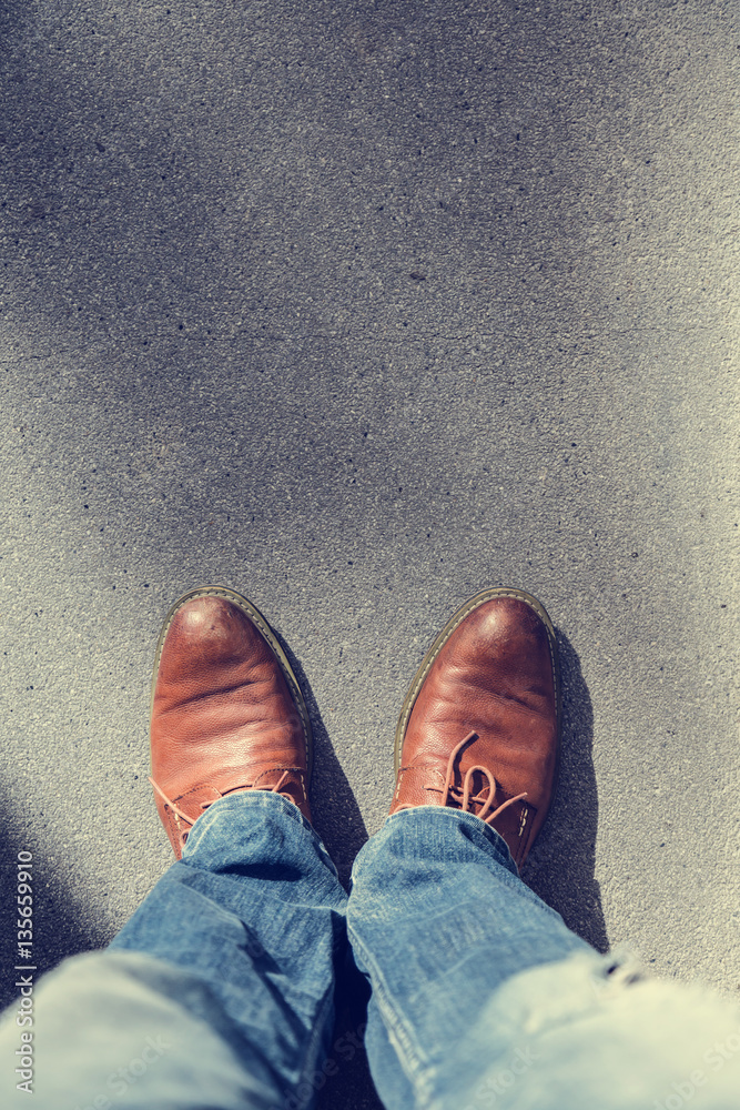 man brown leather shoe with blue jeans on street road with free