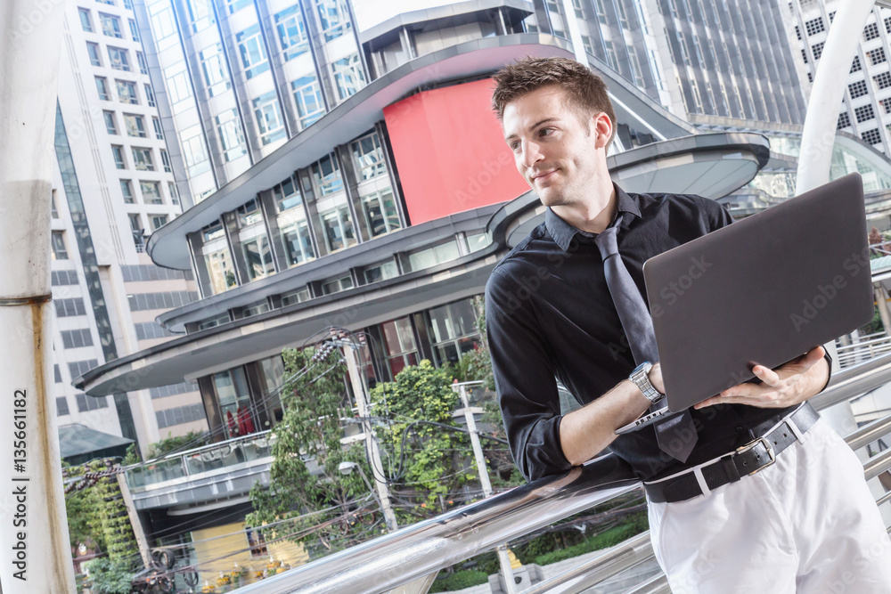 Caucasian businessman use of the notebook computer at outdoor