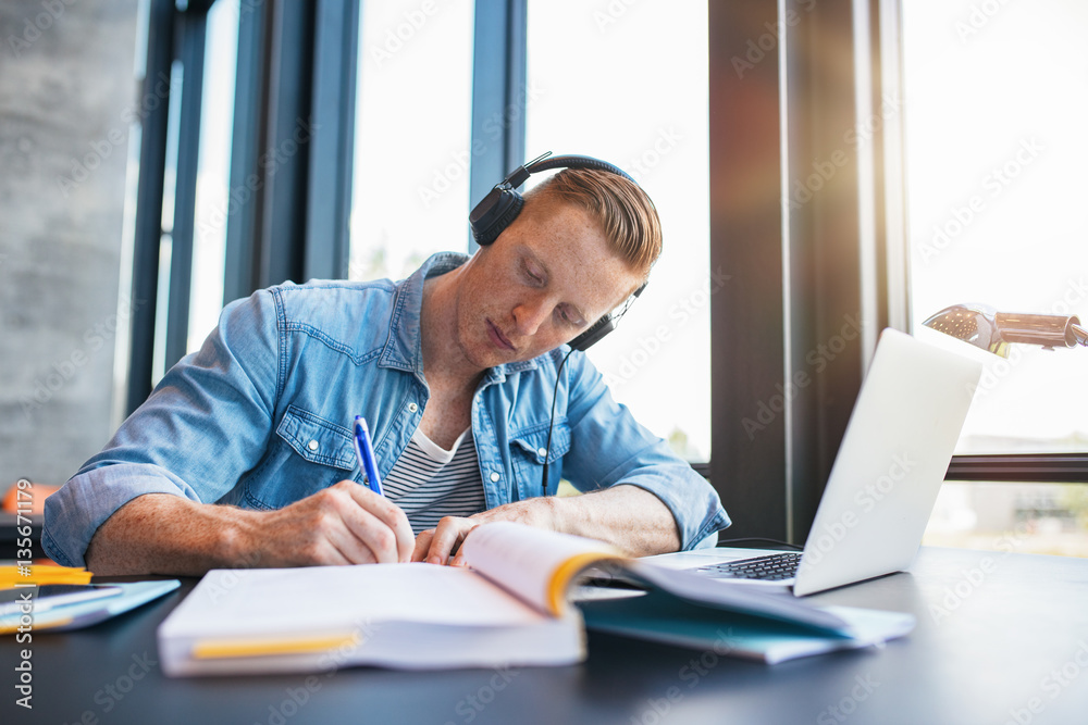 Young man studying in college library