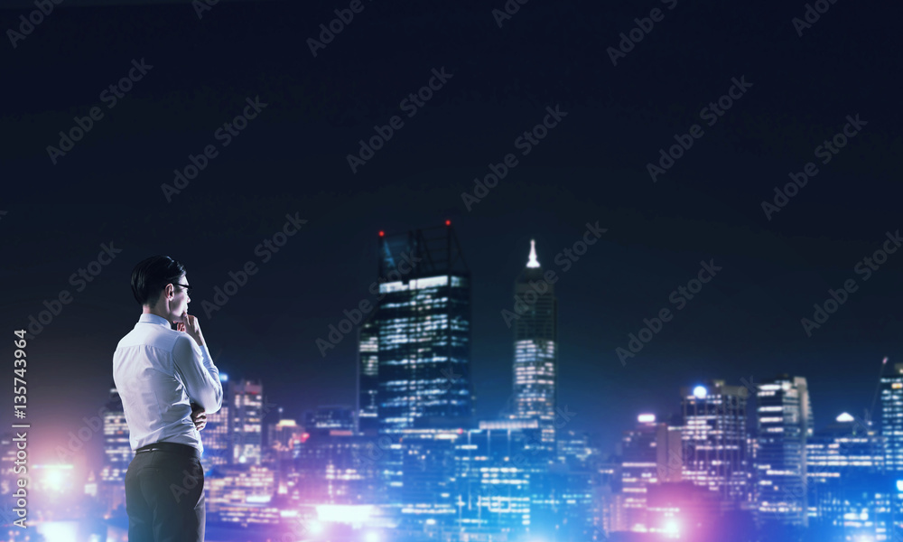 Businessman viewing night glowing city