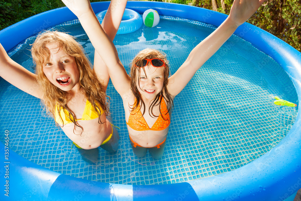 Friends raising their hands up in swimming pool