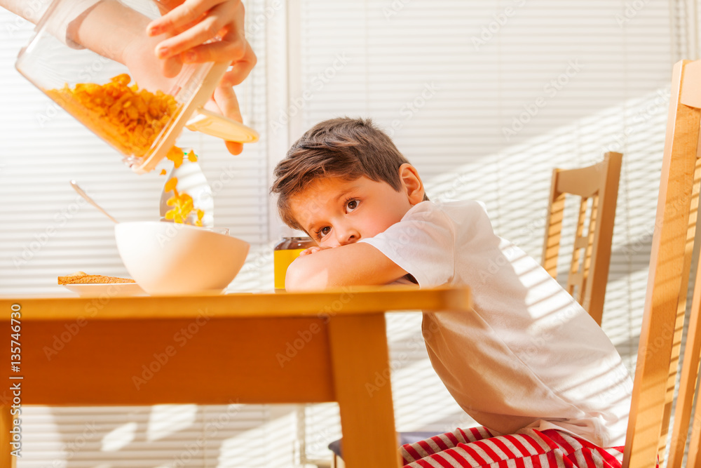 Little boy waiting for breakfast in sunny morning