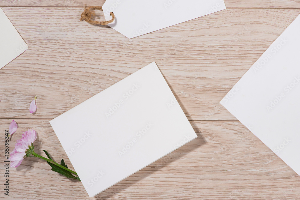 Pink flowers and empty paper for your text on wooden background