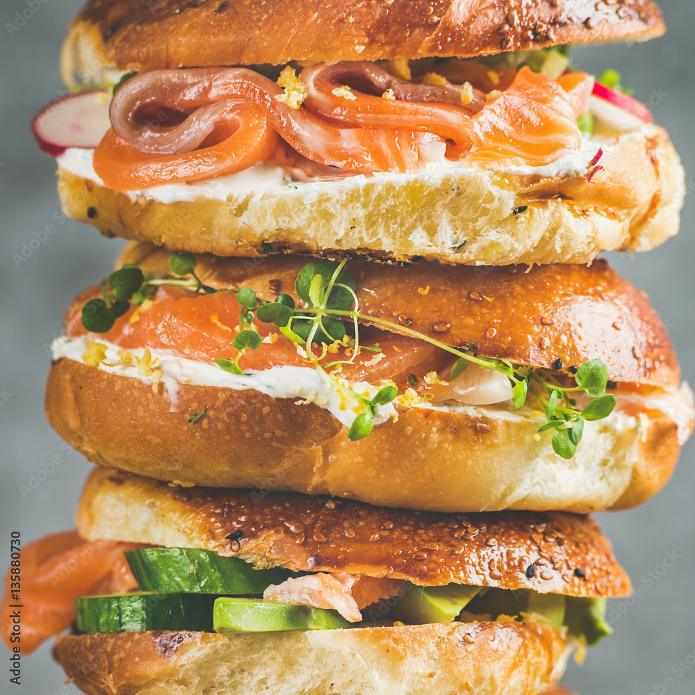 Close-up of of Bagels with salmon, eggs, vegetables, capers, fresh herbs and cream-cheese, grey conc