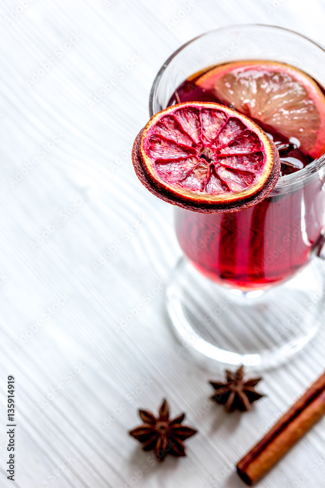 mulled wine with spices in cup on wooden background