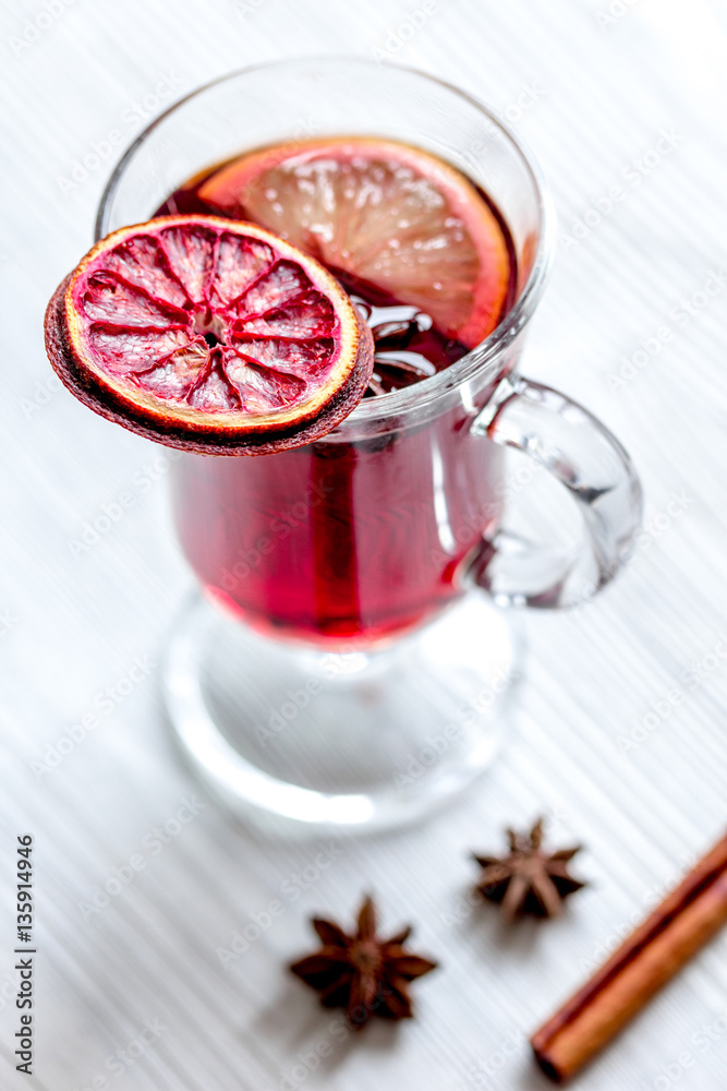 mulled wine with spices in cup on wooden background