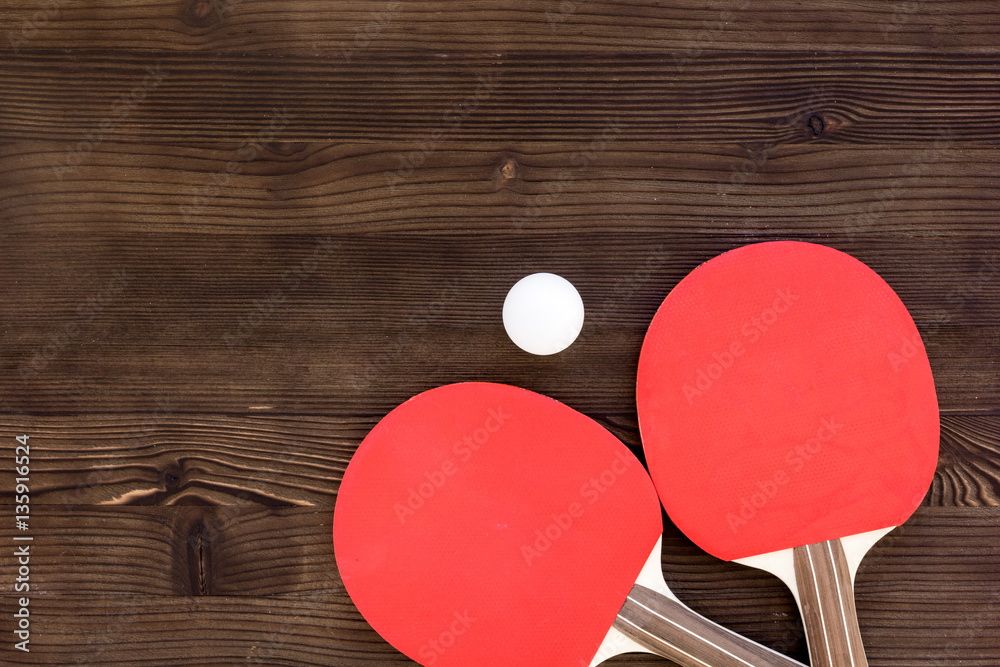 Red racket for ping pong ball wooden background top view