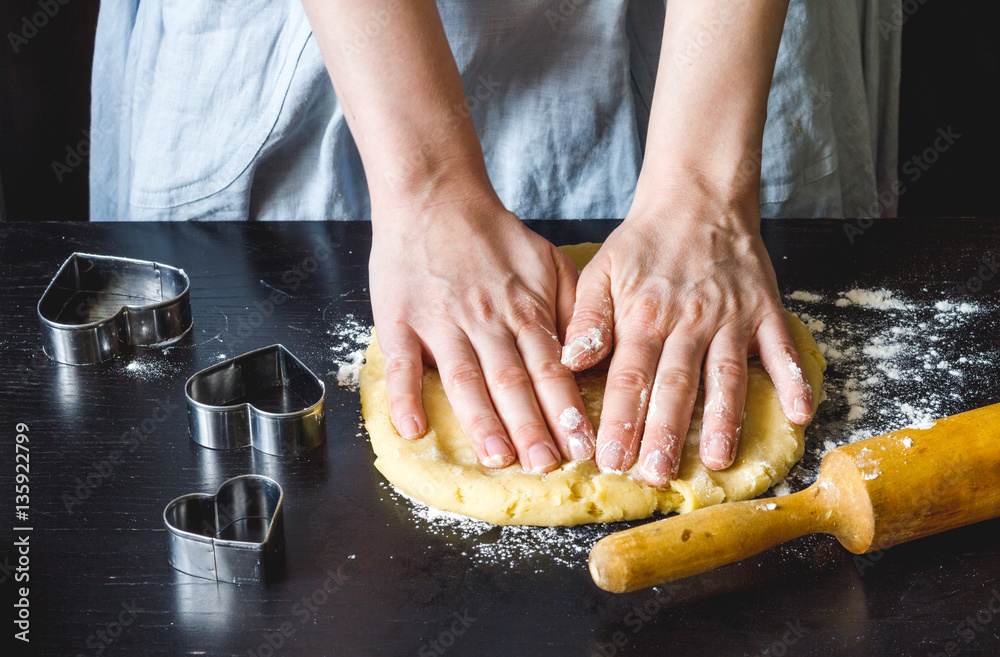 cooking homemade cookies with hands on dark background