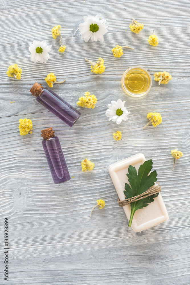 organic cosmetics with camomile on wooden background top view