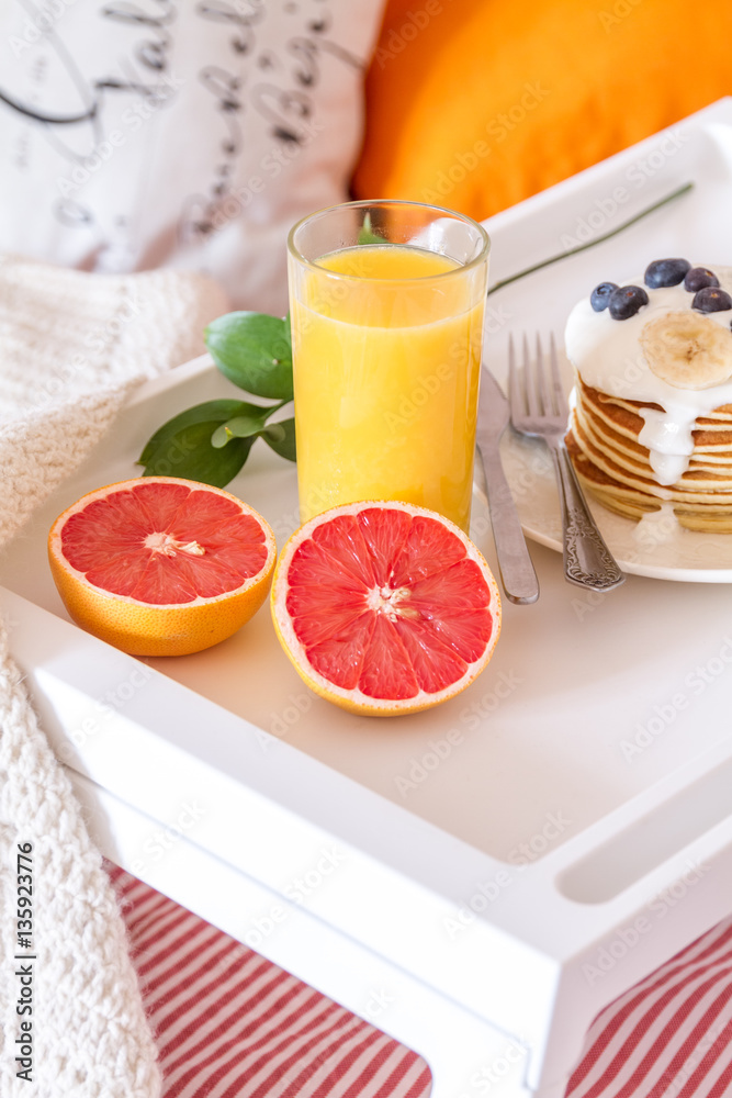 concept of breakfast in bed on tray with juice