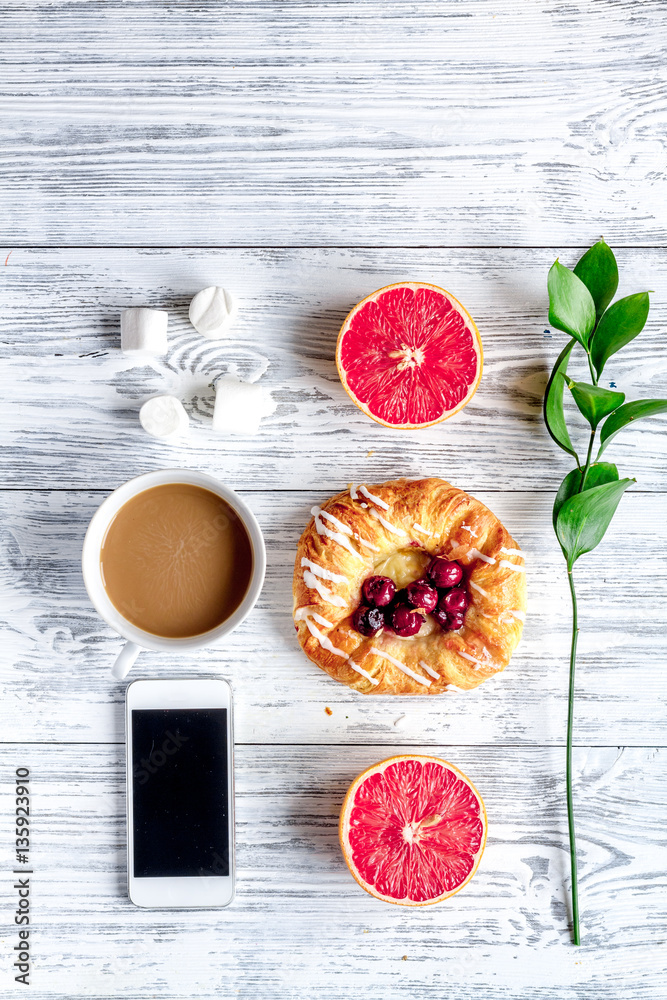 Breakfast concept with flowers on wooden background top view