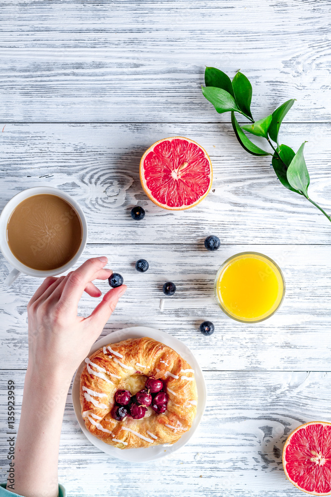 Breakfast concept with flowers on wooden background top view