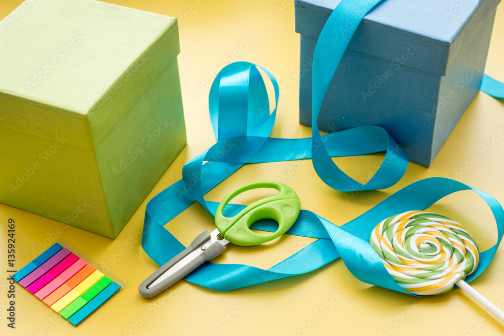 wrapping gifts in box for holiday on yellow background