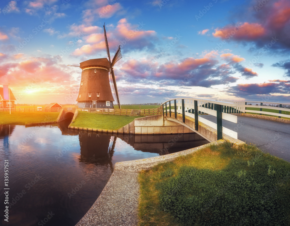 Windmill and bridge near the water canal at sunrise in Netherlands. Traditional dutch windmill again