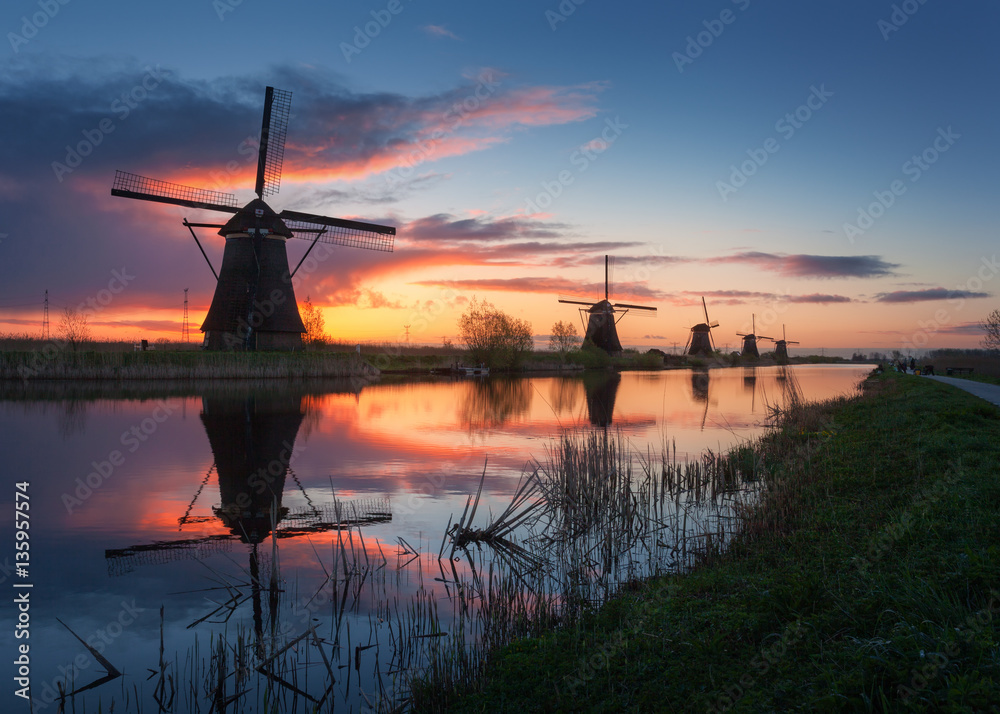 Silhouette of windmills at sunrise in Kinderdijk, Netherlands. Rustic landscape with traditional dut