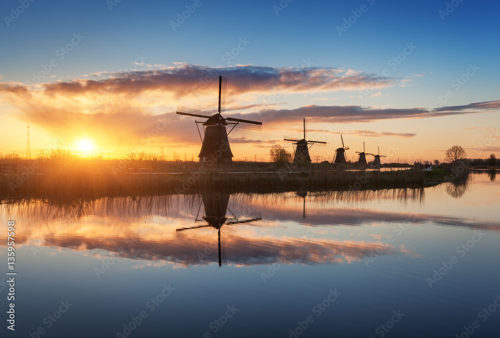 Silhouette of windmills. Rustic landscape with traditional dutch windmills near the water canals wit