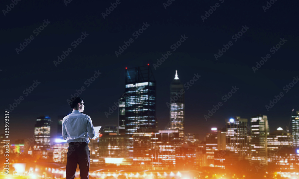 Businessman viewing night glowing city