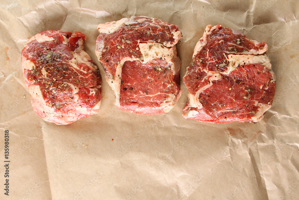 Raw Ribeye steak with spices.