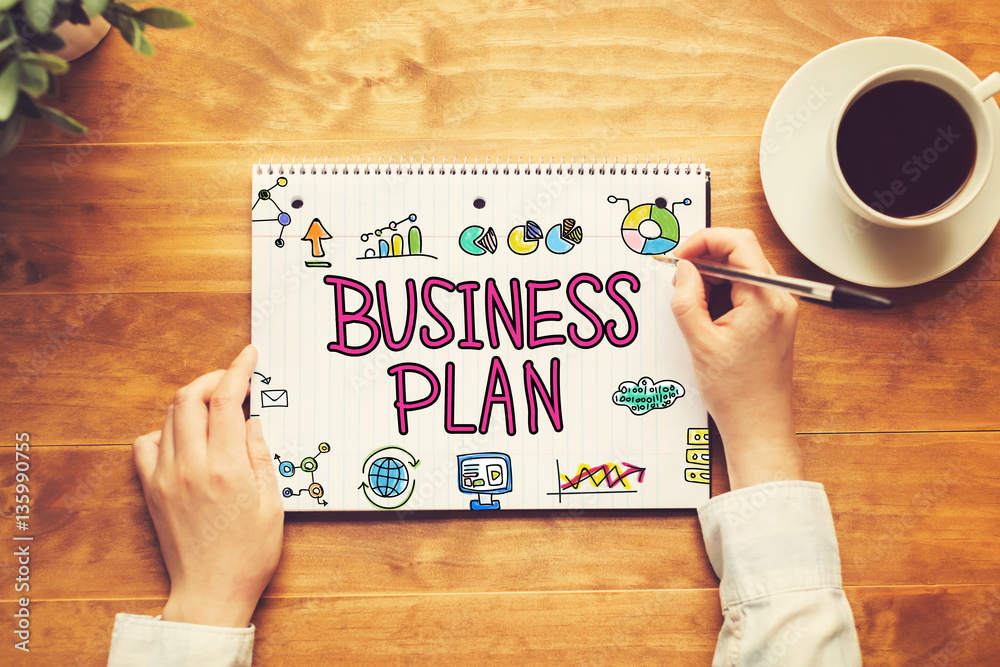 Business Plan text with a person holding a pen