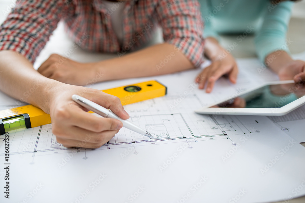 Attractive young asian adult couple looking at house plans.