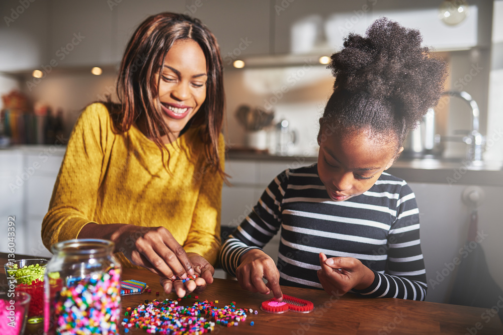 Attractive parent helping child with bead project