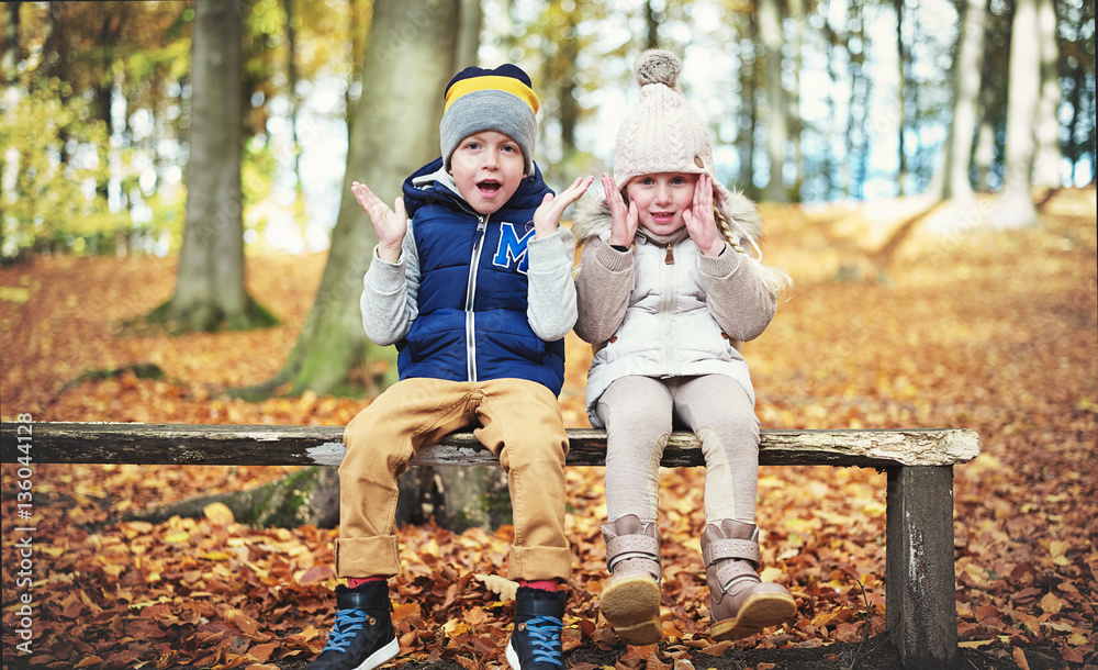 Two sitting children with their hands up