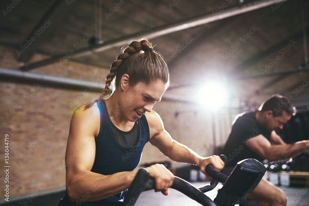 People working hard on exercycle in gym