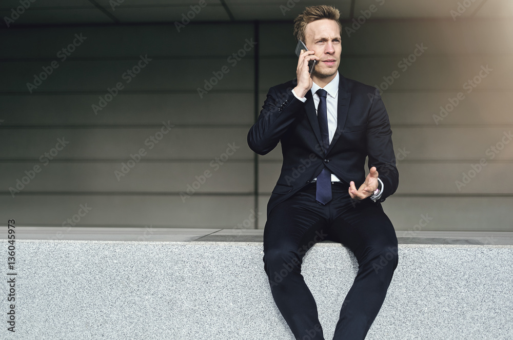 Discussing man wearing suit sits on brick