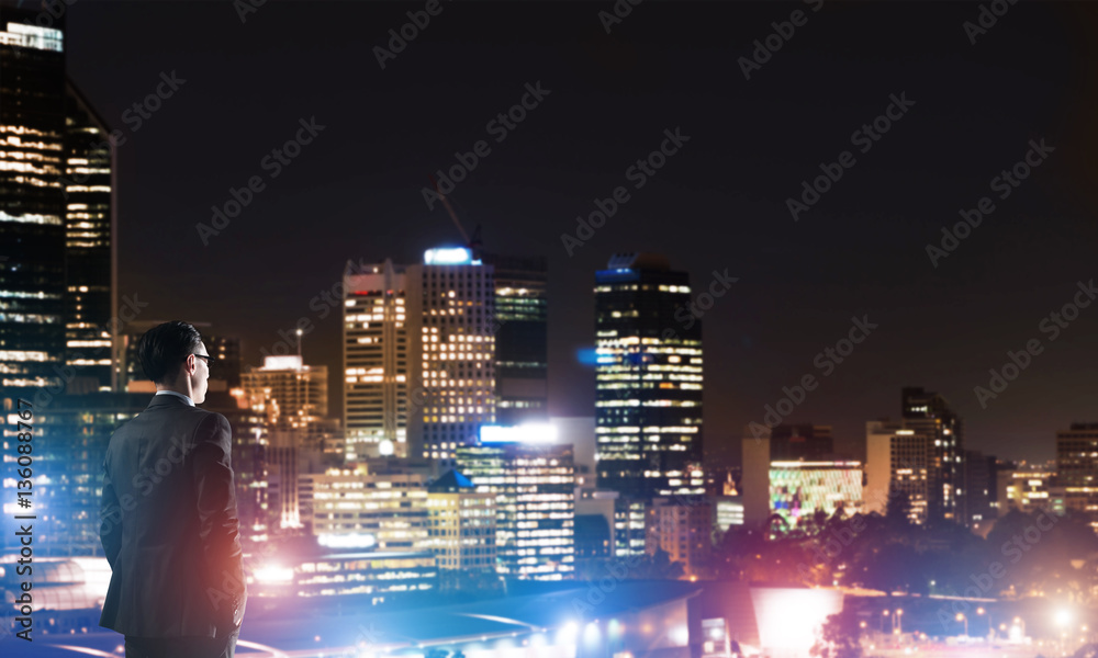 Businessman viewing night glowing city