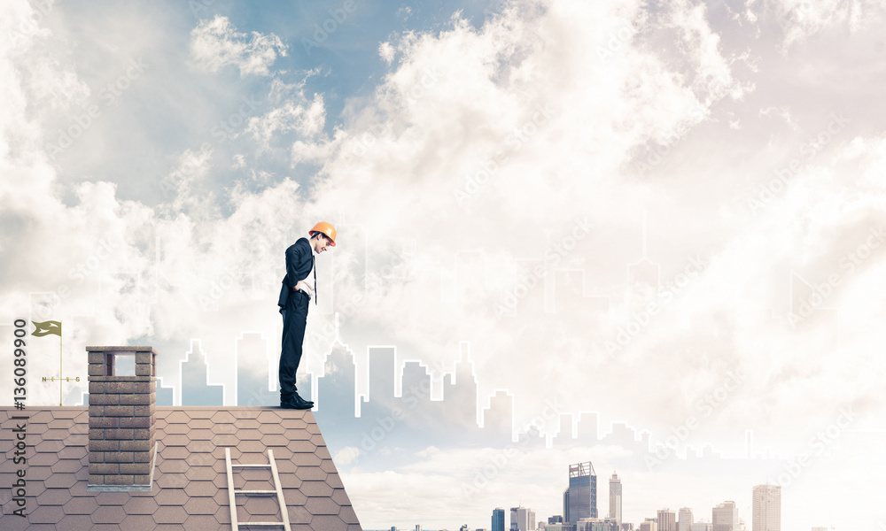 Engineer man standing on roof and looking down. Mixed media