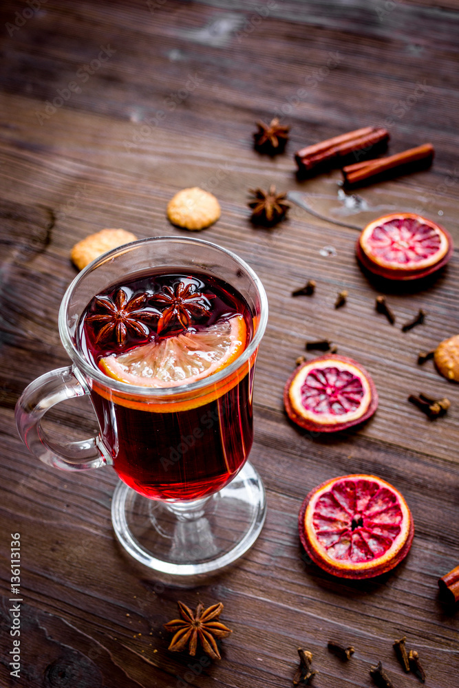 mulled wine with spices in cup on wooden background