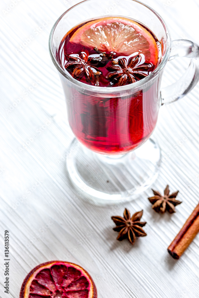 mulled wine with spices in cup on wooden background