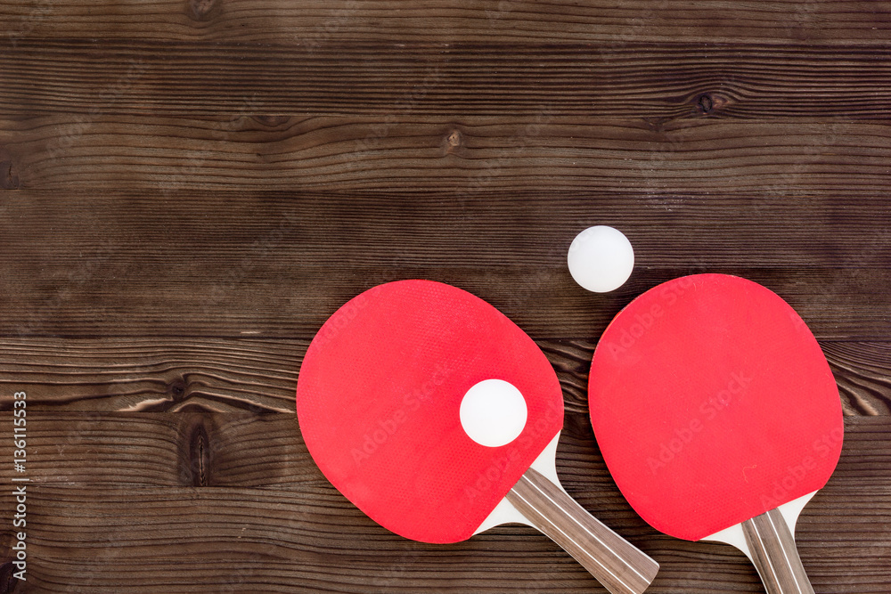 Red racket for ping pong ball wooden background top view